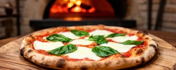 Pizza artisanale sortant du four à bois avec mozzarella fondante à Marseille